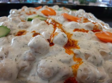 Servis tabağında lezzetli tereyağlı Türk mantısı.