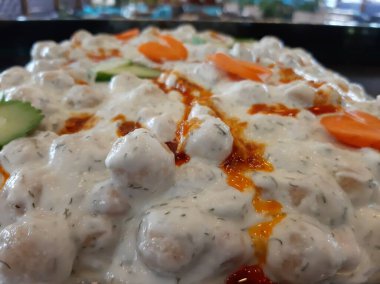 Servis tabağında lezzetli tereyağlı Türk mantısı.