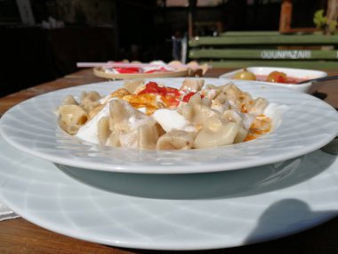 Servis tabağında lezzetli tereyağlı Türk mantısı.