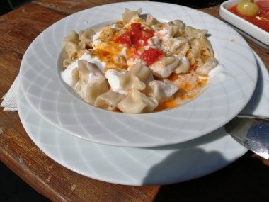 Servis tabağında lezzetli tereyağlı Türk mantısı.