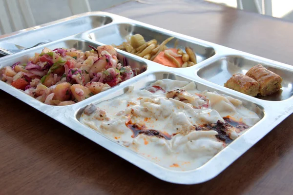 Servis tabağında lezzetli tereyağlı Türk mantısı.