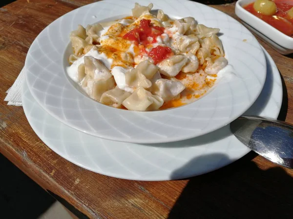 Servis tabağında lezzetli tereyağlı Türk mantısı.