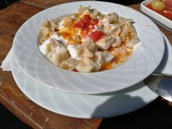 Servis tabağında lezzetli tereyağlı Türk mantısı.