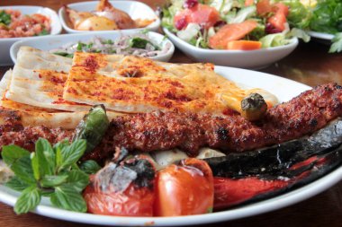 Tabakta lezzetli Adana kebapları ve salatalar