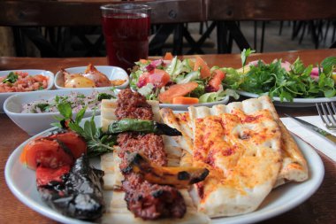 Tabakta lezzetli Adana kebapları ve salatalar