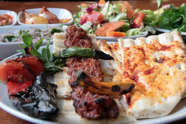 Tabakta lezzetli Adana kebapları ve salatalar