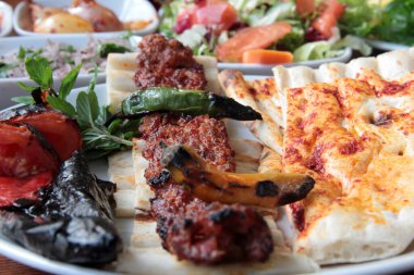 Tabakta lezzetli Adana kebapları ve salatalar