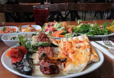 Tabakta lezzetli Adana kebapları ve salatalar