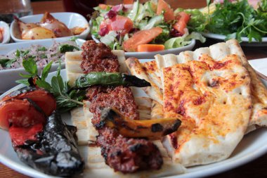 Tabakta lezzetli Adana kebapları ve salatalar