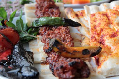 Tabakta lezzetli Adana kebapları ve salatalar
