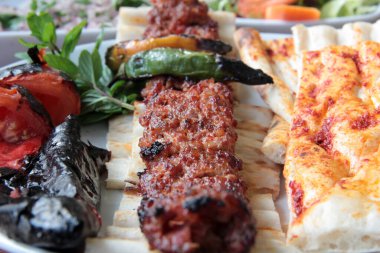 Tabakta lezzetli Adana kebapları ve salatalar