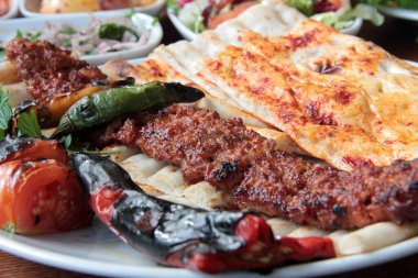 Tabakta lezzetli Adana kebapları ve salatalar