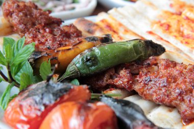 Tabakta lezzetli Adana kebapları ve salatalar