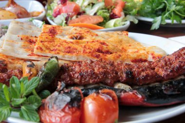 Tabakta lezzetli Adana kebapları ve salatalar