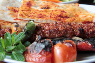 Tabakta lezzetli Adana kebapları ve salatalar
