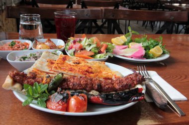 Tabakta lezzetli Adana kebapları ve salatalar