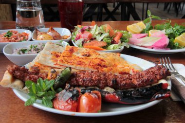 Tabakta lezzetli Adana kebapları ve salatalar