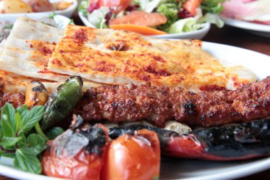 Tabakta lezzetli Adana kebapları ve salatalar