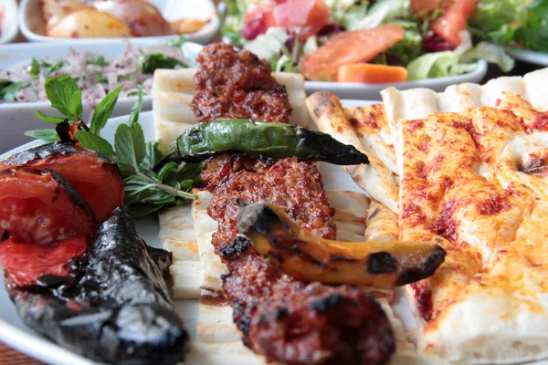 Tabakta lezzetli Adana kebapları ve salatalar