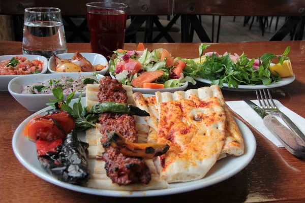 Tabakta lezzetli Adana kebapları ve salatalar