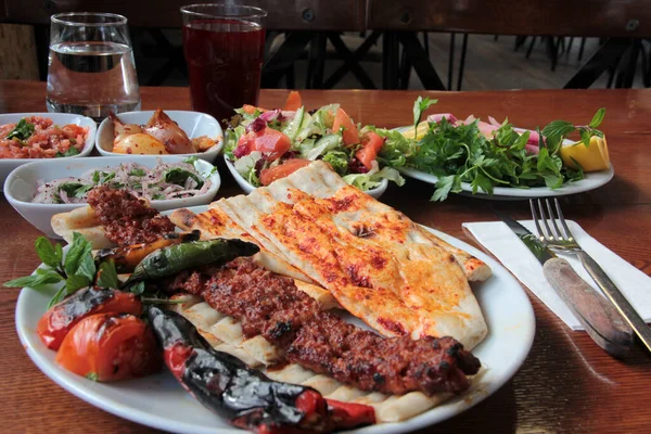 Tabakta lezzetli Adana kebapları ve salatalar