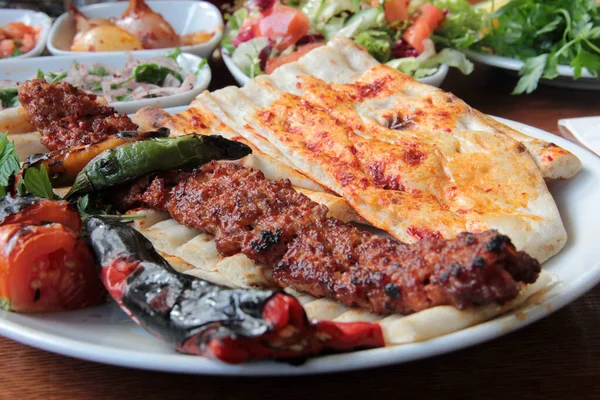 Tabakta lezzetli Adana kebapları ve salatalar