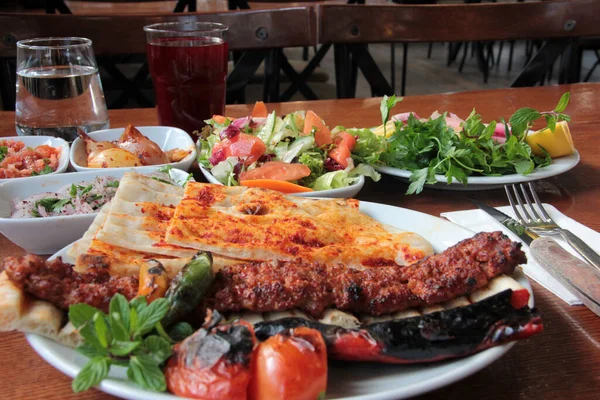 Tabakta lezzetli Adana kebapları ve salatalar