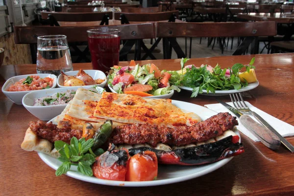 Tabakta lezzetli Adana kebapları ve salatalar
