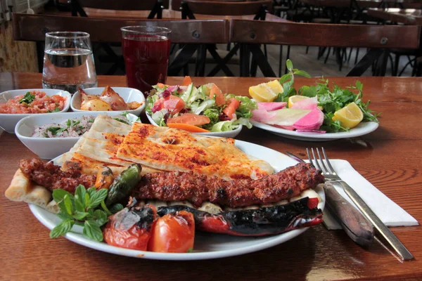 Tabakta lezzetli Adana kebapları ve salatalar