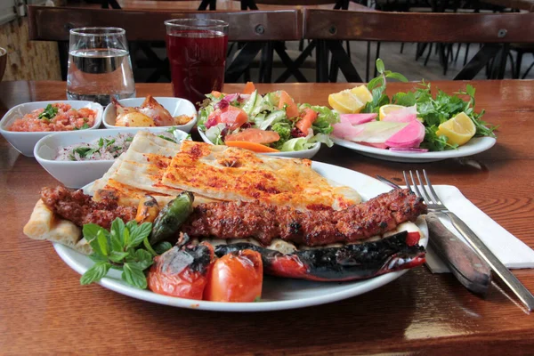Tabakta lezzetli Adana kebapları ve salatalar