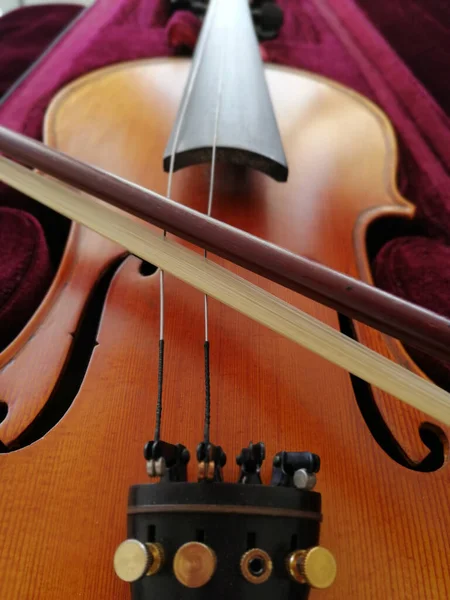Violin and bow in dark red case. Close up