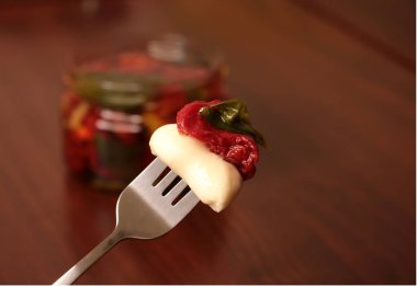 Çatalında mozzarella olan kurutulmuş kırmızı domates.