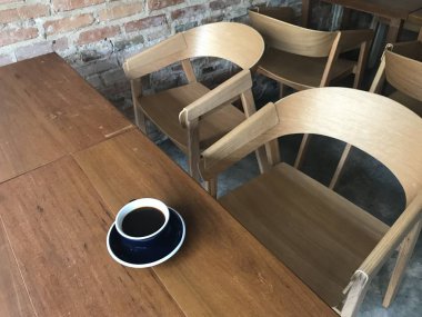 kimse üzerine sıcak kahve ve eski tuğla duvar kafede güzel antika arka plan üzerinde sadece bir fincan ile klasik ahşap kahverengi masada oturan görünüm görüntüsünü yüksek açı