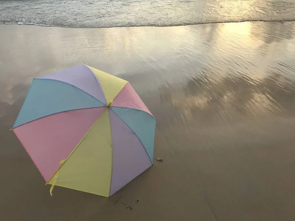 Colorato Ombrello Pastello Mettendo Sulla Spiaggia Chiara Con Onda Mare — Foto Stock