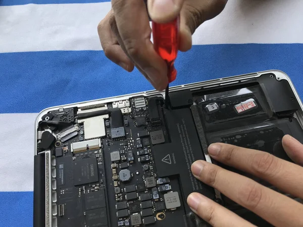 Phuket, Tayland 15 Mart 2019: kullanıcı elma yağmurluk kitap dizüstü pil tek başına evde değiştirmek nasıl gösteren