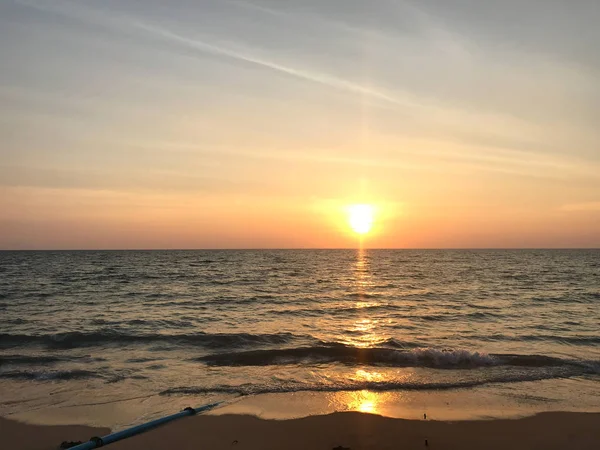 La luce luminosa del tramonto riflette sulla superficie del mare e sulla spiaggia — Foto Stock