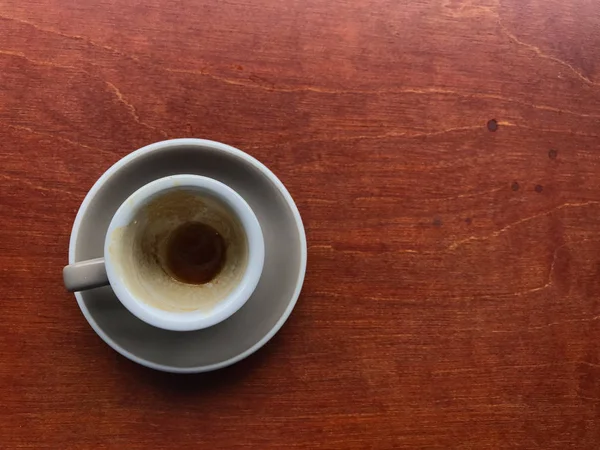 Xícara cinza claro e pires de café expresso acabado na mesa de madeira marrom — Fotografia de Stock