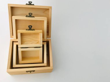 El işi. Üç doğal kauçuk kahverengi boş tahta kutu. Çerçevenin sağ tarafında fotokopi alanı olan beyaz zemin üzerinde üst üste konmuş.