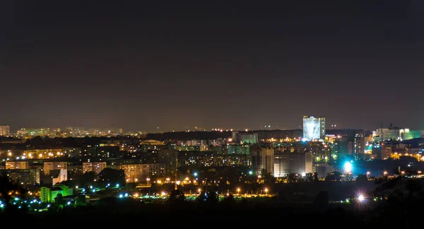 Panorama nocturno de la ciudad con un edificio de gran altura — Foto de Stock
