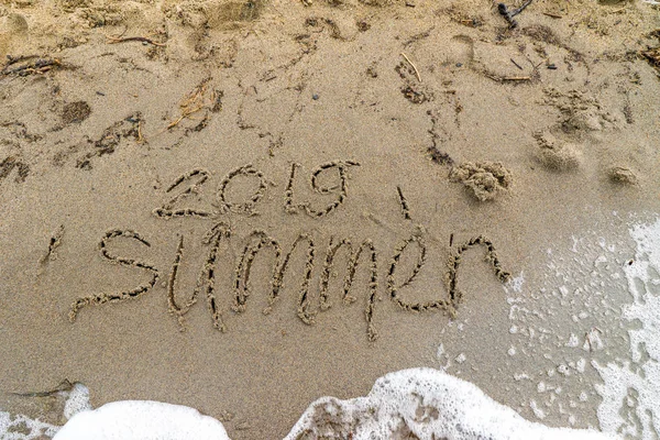Vlny omyjí slovo léto od písku, 2019 — Stock fotografie
