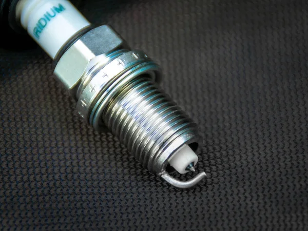 New iridium spark plug on dark background, selective focus — Stock Photo, Image