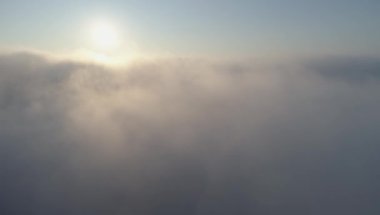 Bulutların arasından yukarı uçan dronun hava atış