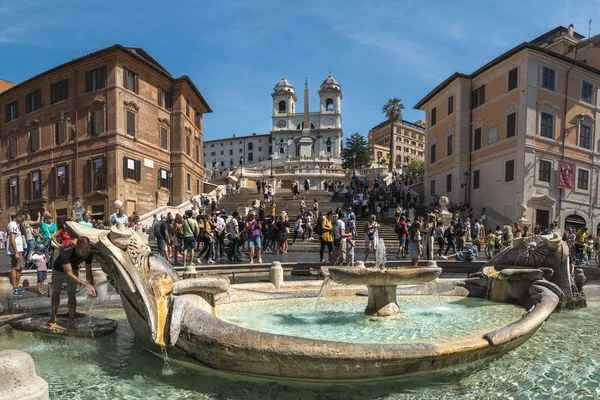 Monumentální schodiště Španělské schody s Trinit dei Monti kostelem na vrcholu. Turisté na náměstí Piazza di Spagna u fontány v Římě. — Stock fotografie