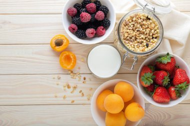 Tahıl, süt, meyve ve böğürtlenli kahvaltı kompozisyonu. Sağlıklı beslenme konsepti, yaz kahvaltısı, üst manzara, kopyalama alanı.