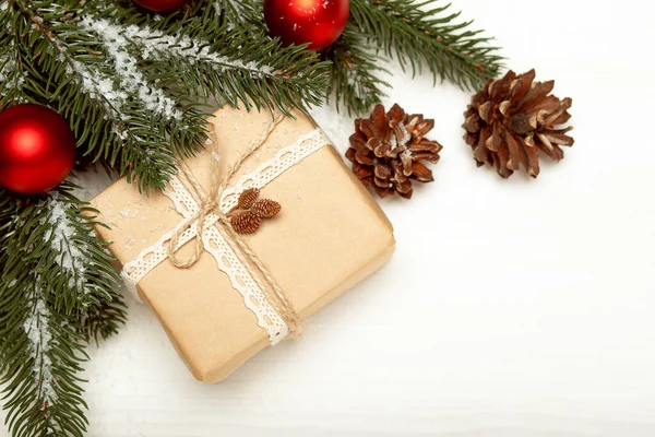 クリスマスの組成 クリスマスの贈り物 白い木製の背景に雪と松のコーン コピースペース トップビュー — ストック写真