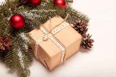 Noel arka planında köknar ağacı dalı, çam kozalakları, hediye kutusu ve kırmızı toplar vardı. Tatil kavramı.
