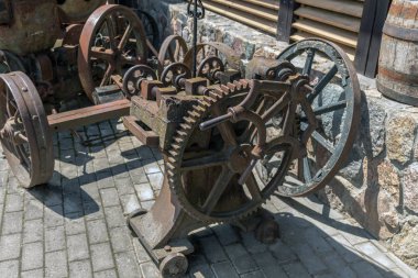 Geçen yüzyılın eski, paslı tarım makineleri, hangarın yanında duruyor..