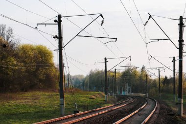 Arka planda otomatik geçişli çift elektrikli demiryolu hattı.