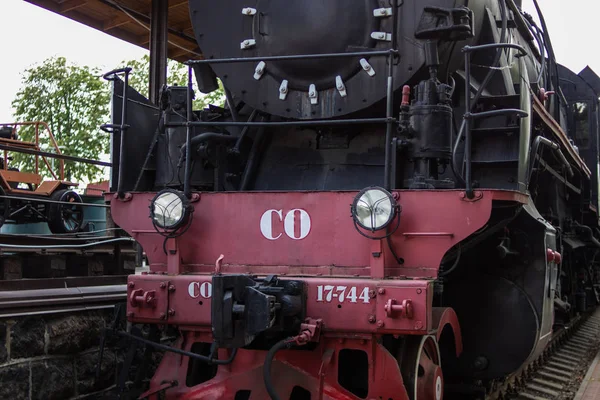 Old steam train at the station. Front view, headlights, details. Close-up.