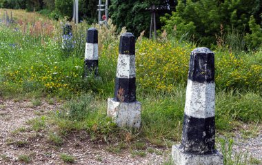 Yolun kenarında beton kolonlar var..